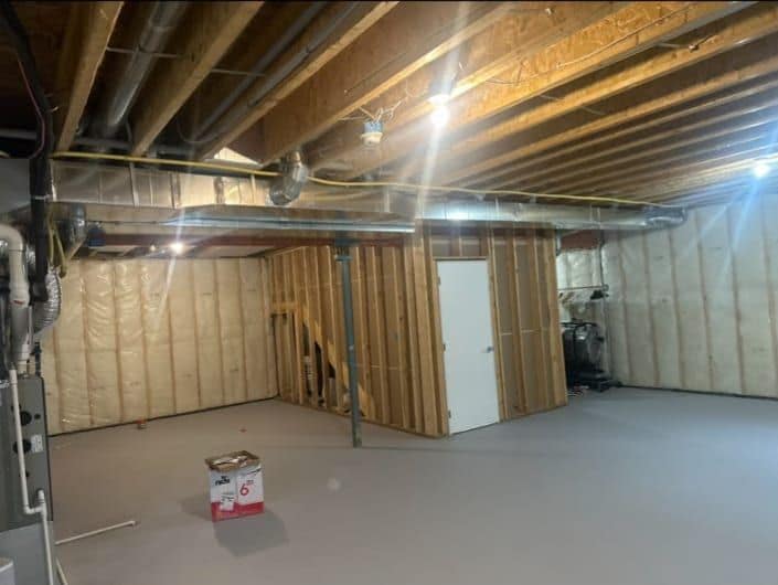 Basement Development — unfinished basement before renovation, exposed framing and insulation
