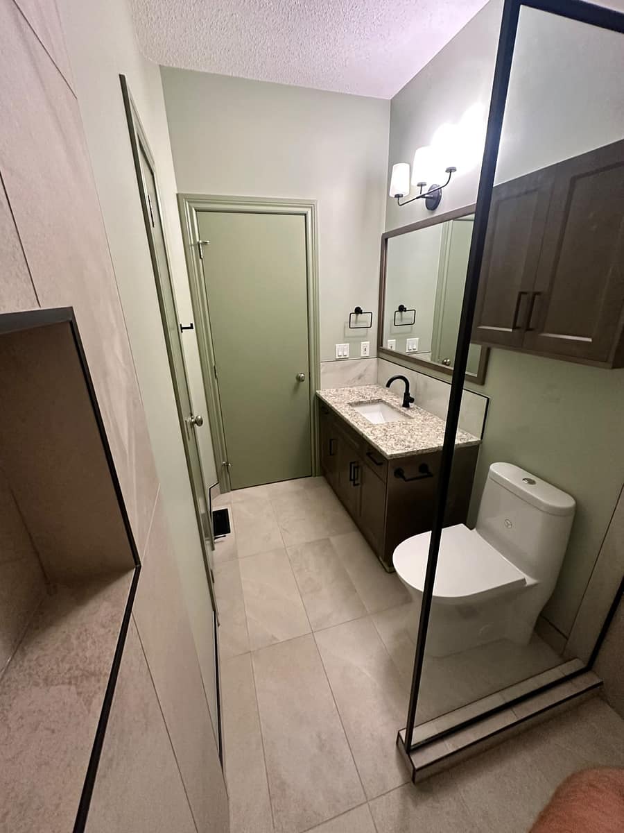 Bungalow Home Renovation — view from inside the walk-in shower showing recessed niche, glass partition and vanity reflected through the glass