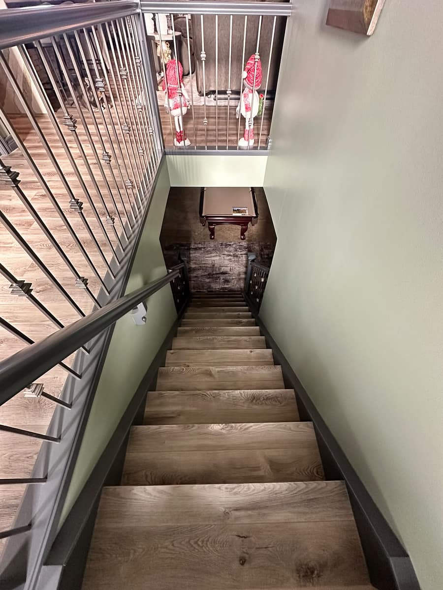 Bungalow Home Renovation — refinished staircase with light oak treads, dark handrail and sage green walls viewed from above