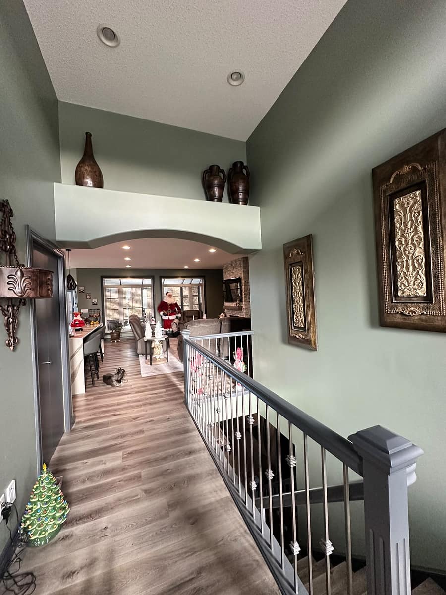 Bungalow Home Renovation — upper-level hallway with ornate gold wall plaques, recessed lighting and view toward the kitchen