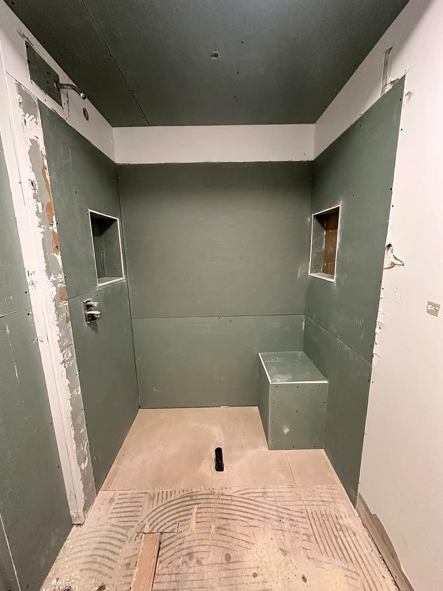 Chappelle Custom Bathroom Renovation — walk-in shower framing with moisture-resistant backer board, shower valve and drain pipe before waterproofing