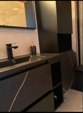 Chappelle Custom Bathroom Renovation — close-up of the matte-black vanity with integrated sink and black marbled cabinetry