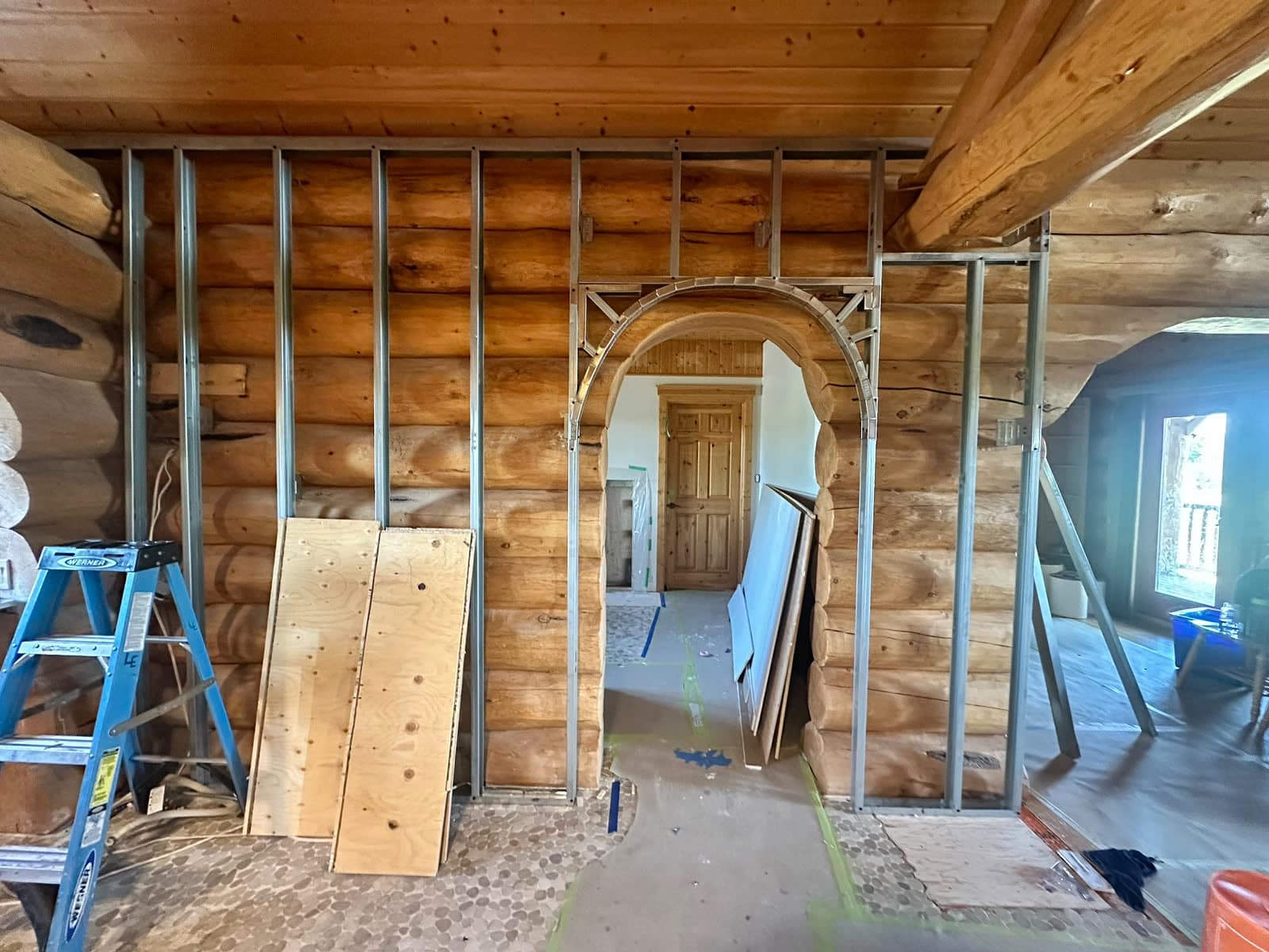 Custom Log Home Interior Renovation — front view of custom metal framing around the arched log opening