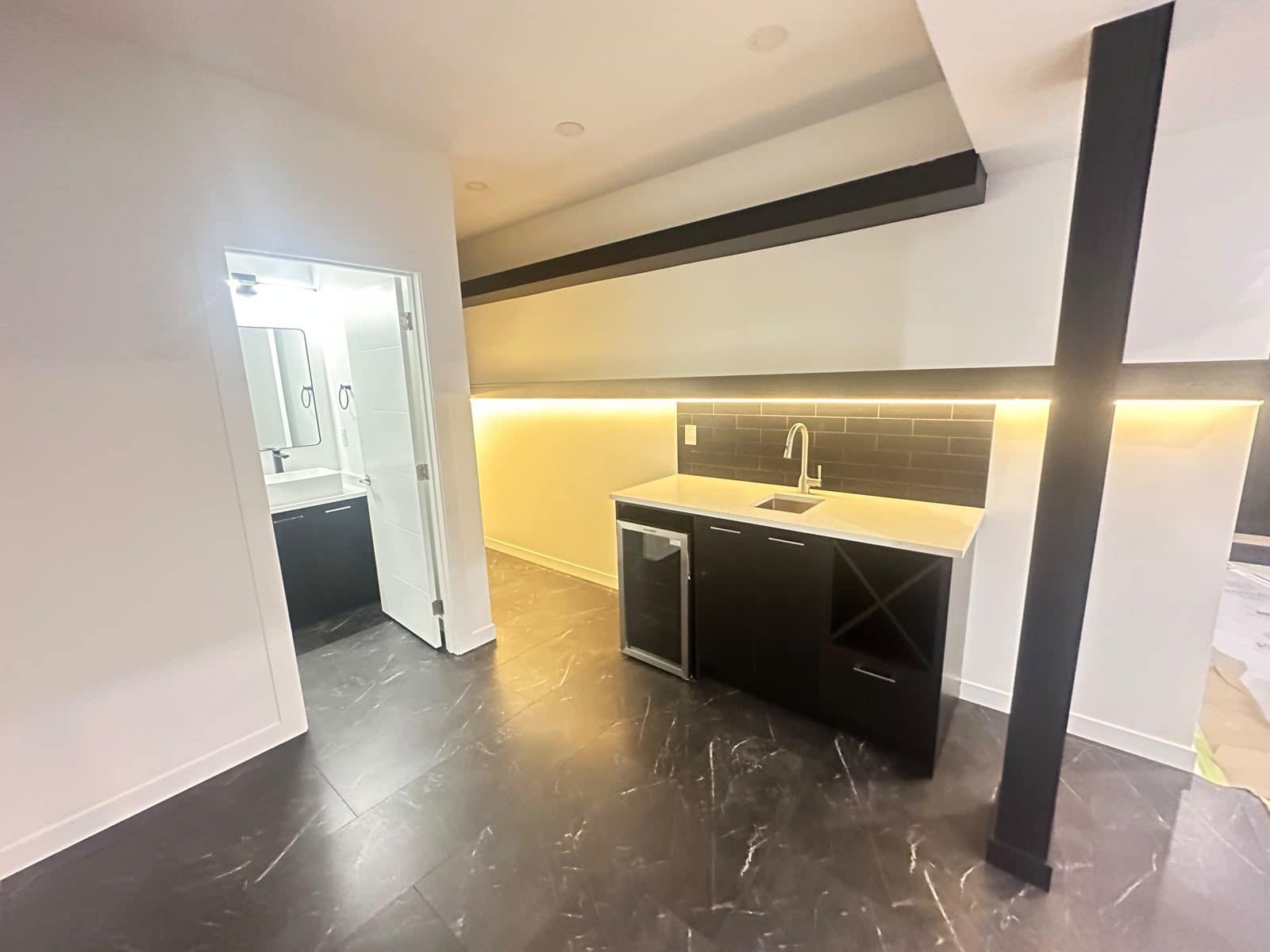 Basement Development — custom wet bar with beverage fridge, wine rack, quartz countertop and LED accent lighting