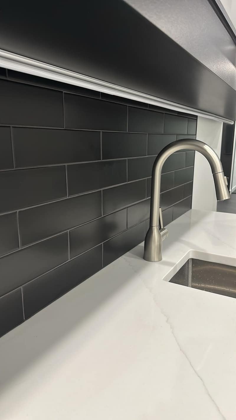 Basement Development — private bar detail with dark tile backsplash and brushed-steel faucet