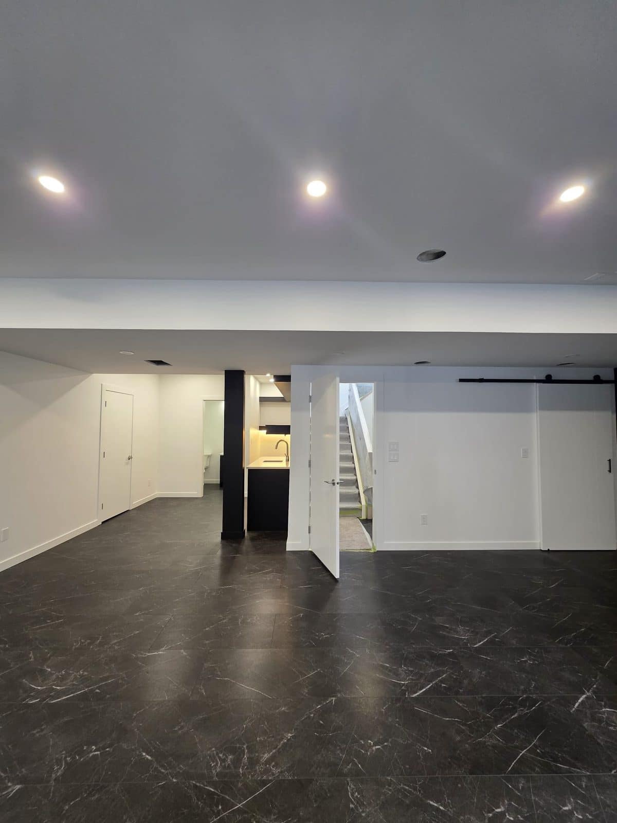 Finished Cadavid basement with custom cabinetry and quartz countertop