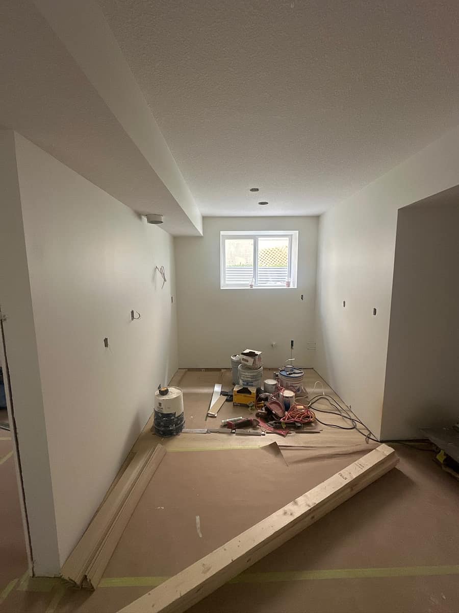 Framed kitchen room during construction — protective floor covering, materials and tools staged