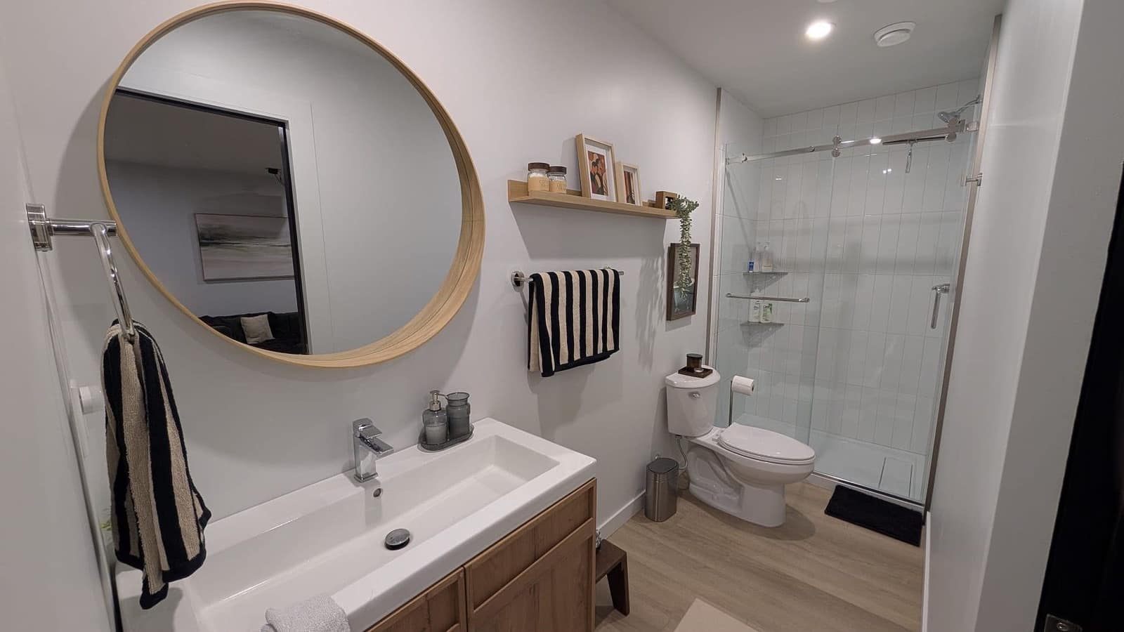 South Edmonton basement full bathroom with round wood-framed mirror, wood vanity and glass walk-in shower