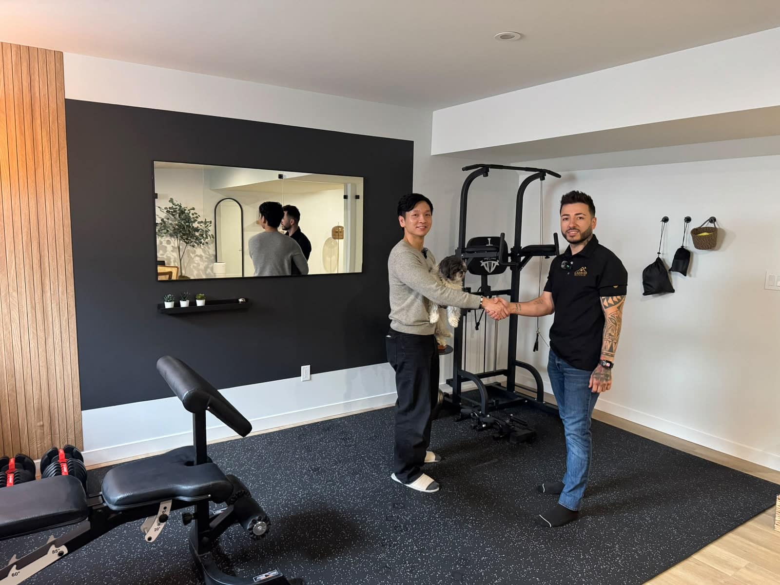 South Edmonton basement home gym with weight bench, dumbbells, power tower and mirrored accent wall