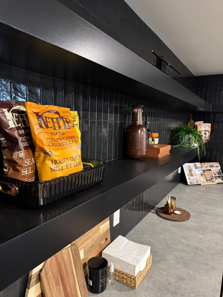 South Edmonton basement kitchen with matte black floating shelves, vertical black tile backsplash and black countertop