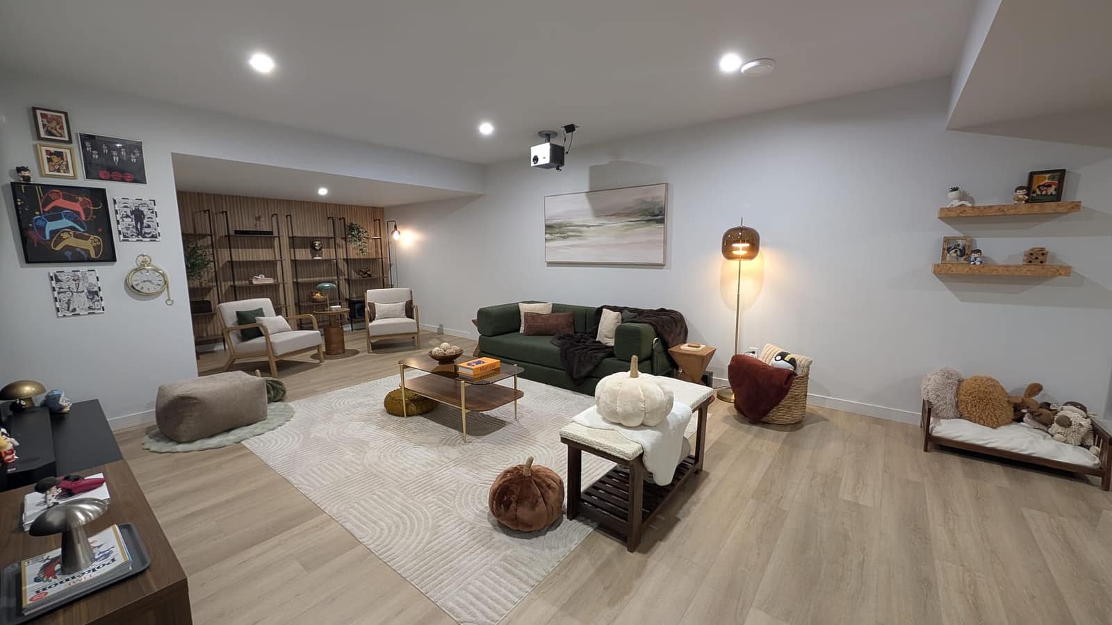 South Edmonton basement living room with wood shelving, green sofa, gallery wall and reading corner